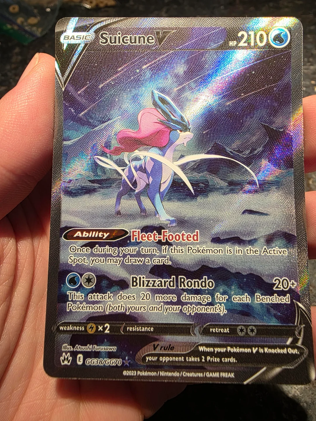 Close-up of a genuine Suicune V Pokémon card showing raised texture and holographic light movement